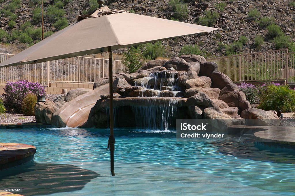 Guarda-chuva na frente da piscina de pedra - Foto de stock de Piscina royalty-free