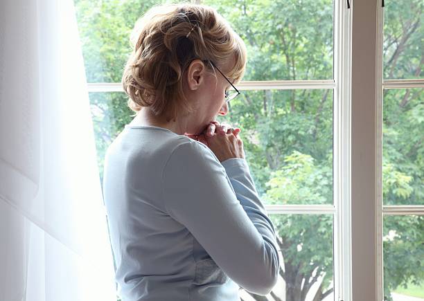istock Woman Praying at Window 176017993
