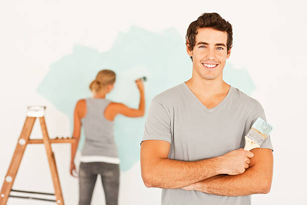istock Young man holding paint bruush with wife at the back 176018532