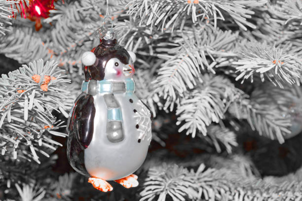 A toy penguin on a Christmas tree. Holiday.