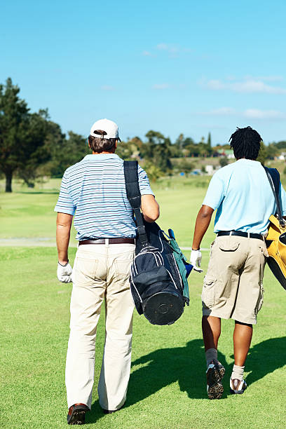 istock Rear view of golfer friends walking on course 176018784