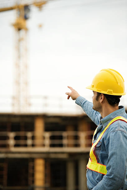 istock Construction Man Wearing Hard Hat at Job Site Pointing 176019415