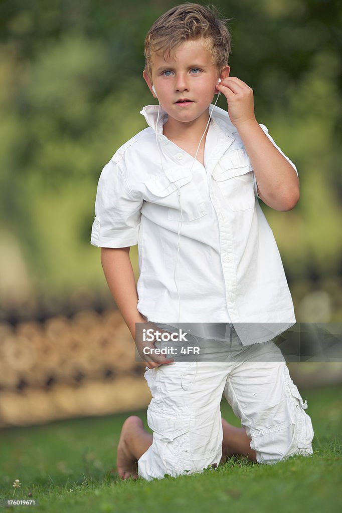 Chłopiec słuchając muzyki na zewnątrz na jego Odtwarzacz mp3 - Zbiór zdjęć royalty-free (4 - 5 lat)