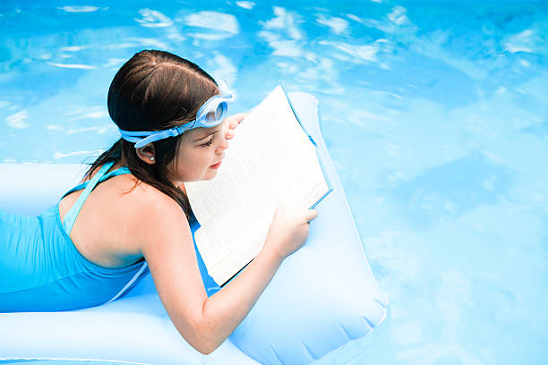 istock Girl reading a book on an air matress 176019765