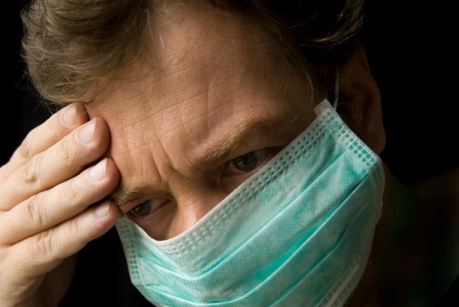 Middle age Caucasian man wearing a mask against the flu and/or swine flu. Different angle below: