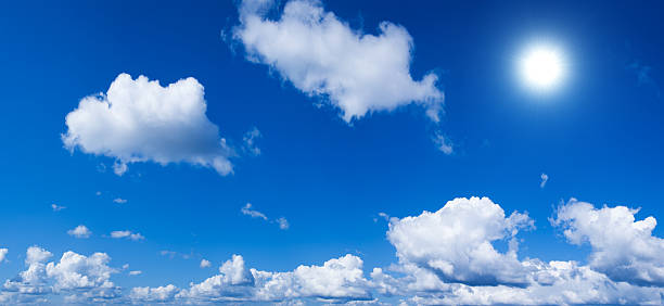 Deep Blue Sky with Clouds and Sun stock photo