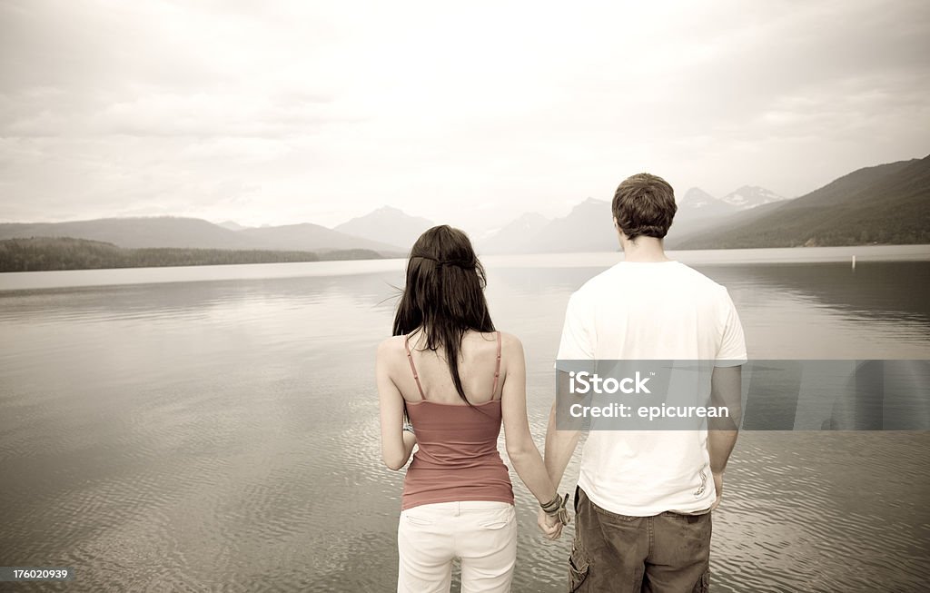 Casal jovem em pé na beira de um lago - Foto de stock de 20 Anos royalty-free
