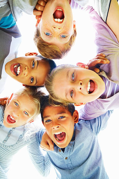 istock Low angle view of cheerful children huddling together 176021366