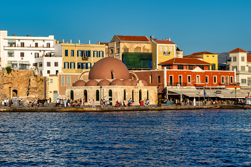 Chania, Crete, Greece - September 27, 2023: A picture of the Lighthouse of Chania, on the right, and the Firka Venetian Fortress, which houses the Maritime Museum of Crete, on the left.