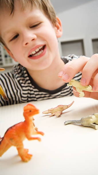 istock Child Playing with Dinosaurs in Kitchen Lifestyle 176022503