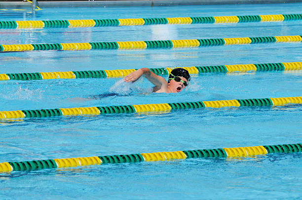 istock Young Boy Freestyle Stroke Swimmer Racing in Pool 176023442