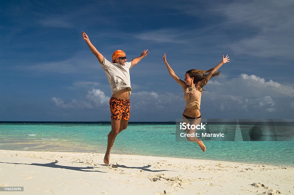 Couple on the Beach Young couple having fun on the beach of Maldives. Active Lifestyle Stock Photo