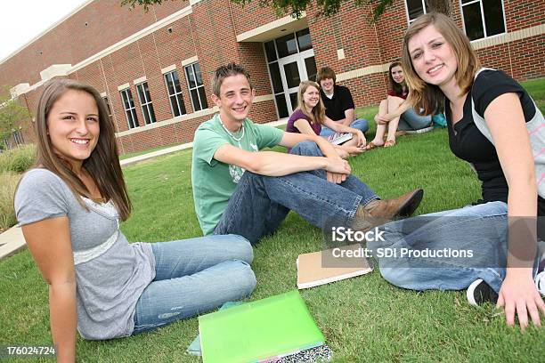 Photo libre de droit de Lycéen Souriant Jeunes Étudiants Assis Sur Lherbe banque d'images et plus d'images libres de droit de 16-17 ans - 16-17 ans, Adolescence, Adolescent