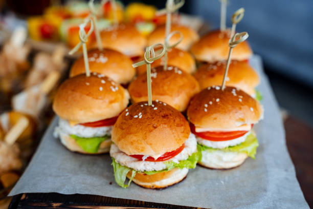istock Hamburger in section side view. Table setting for guests. A set of burgers with chicken, a white bun, lettuce, tomato, sesame. Fast food. 1760255393