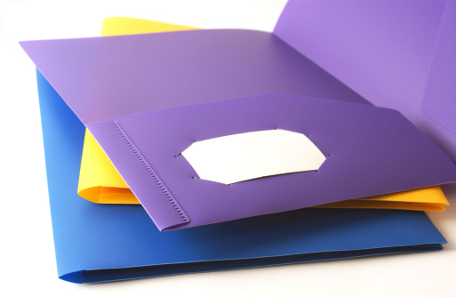 three colorful file folders with a blank business card