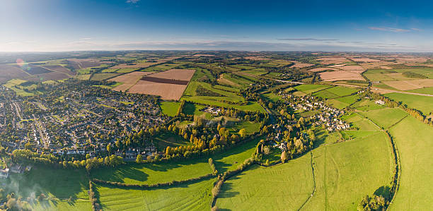 istock Sunlight flaring over country town patchwork farm field panorama 176027102