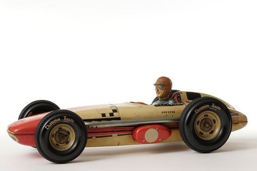 Vintage tin toy racing car isolated on white background.