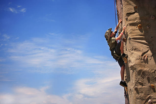 menino pré-adolescente na escalada na rocha - climbing wall rock climbing holding reaching - fotografias e filmes do acervo