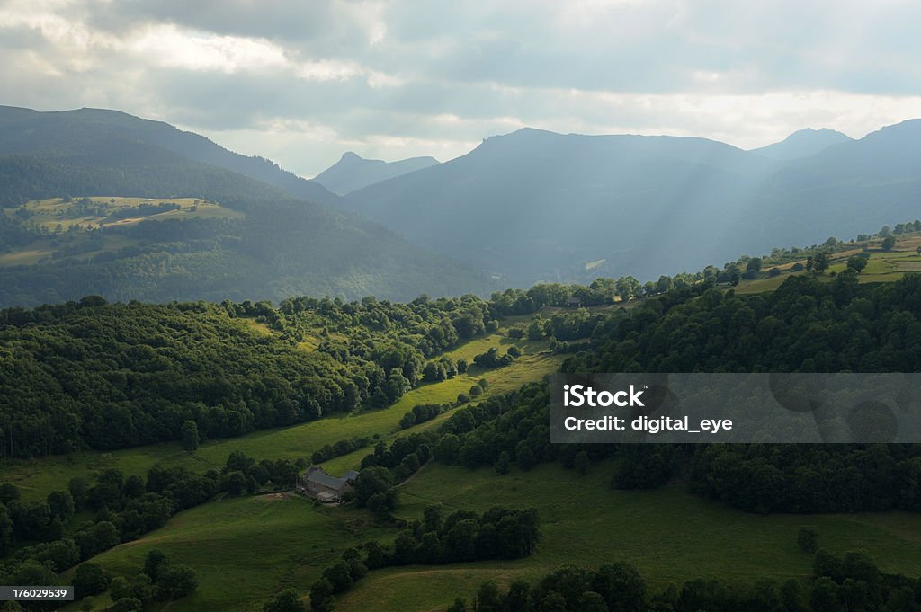 Cantal mountain scene "The mountains of Cantal near the town Murat, Auvergne.The picture was taken from a hill with a small chapel ( Saint Antoine ).Meadows in the sunlight of late afternoon.On the left the mountain Plomb du Cantal, the pyramide in the middle is Puy Griou and the mountain on the right side is Puy Peyre Arse.Similar pictures from Auvergne" Auvergne Stock Photo