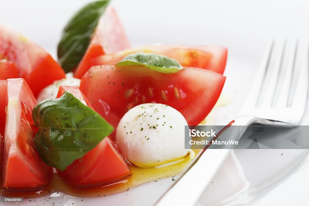 トマトのモツァレラサラダ、「バジル」のクローズアップ - カトラリーのロイヤリティフリーストックフォト