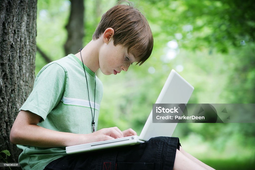 Rapaz bonito, usando o computador na natureza - Foto de stock de 10-11 Anos royalty-free