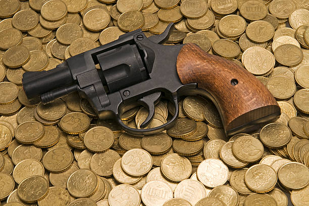 pistola de monedas de oro - gun currency crime mafia fotografías e imágenes de stock