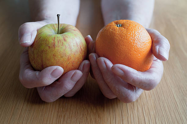 istock Apple And Orange In A Womans Hands 176030286