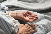 alte-frau-h%C3%A4lt-medikamente-in-der-h