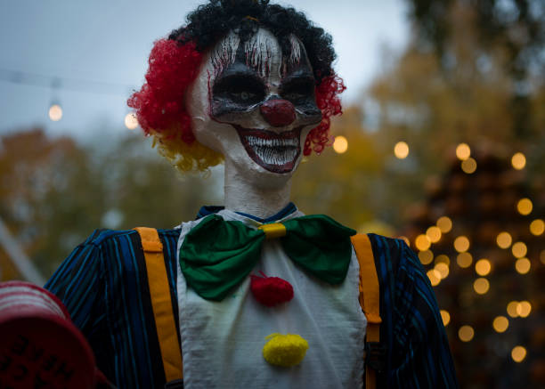 istock Halloween decoration, grinning clown standing on ghosts background 1760320955