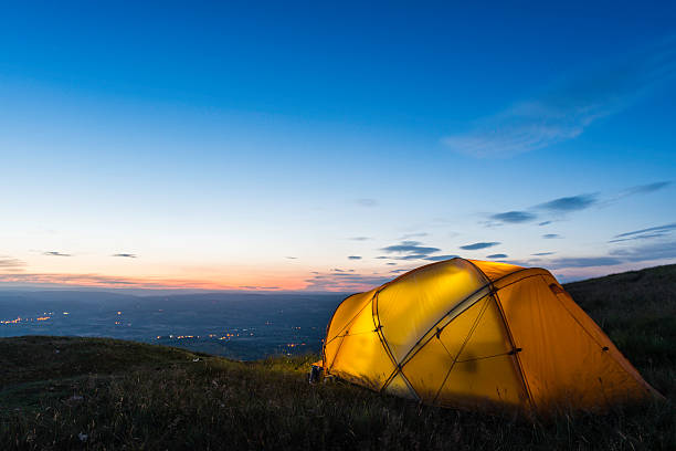 istock Colourful illuminated tent high on mountain below blue dusk skies 176032327
