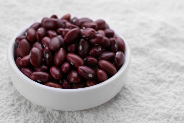 Dark mood variety of vegan seeds, and spices, seasoning on a black wooden table top kitchen or restaurant table, pepper, coriander seeds, chia seeds, red pepper, beans, red beans, black beans, rice, black rice,, wheat, black sesame, close up view with a copy space