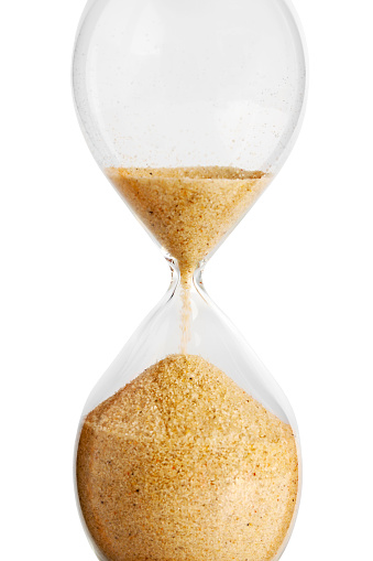 Close-up of a hourglass running out of time. Isolated on white.