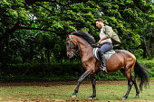 Mid adult man horseback riding at ranch