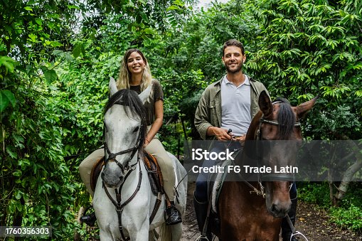 istock Portrait of a couple horseback riding together at ranch 1760356303