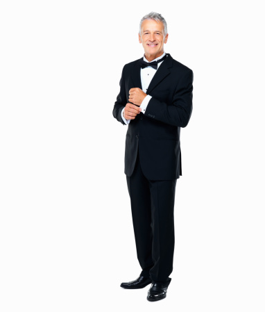 Pleased businessman looking away with hand on chin while sitting on a chair on white studio background
