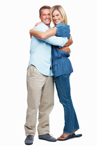 Studio shot of a happy couple in casual clothing smiling at the camera against a white background
