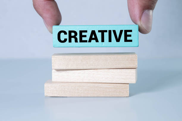 istock a man holding a block of wood labeled CREATIVE. 1760418931