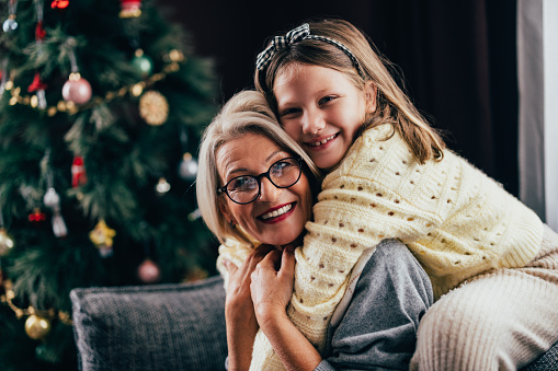 Grandmother and granddaughter hugging at Christmastime.