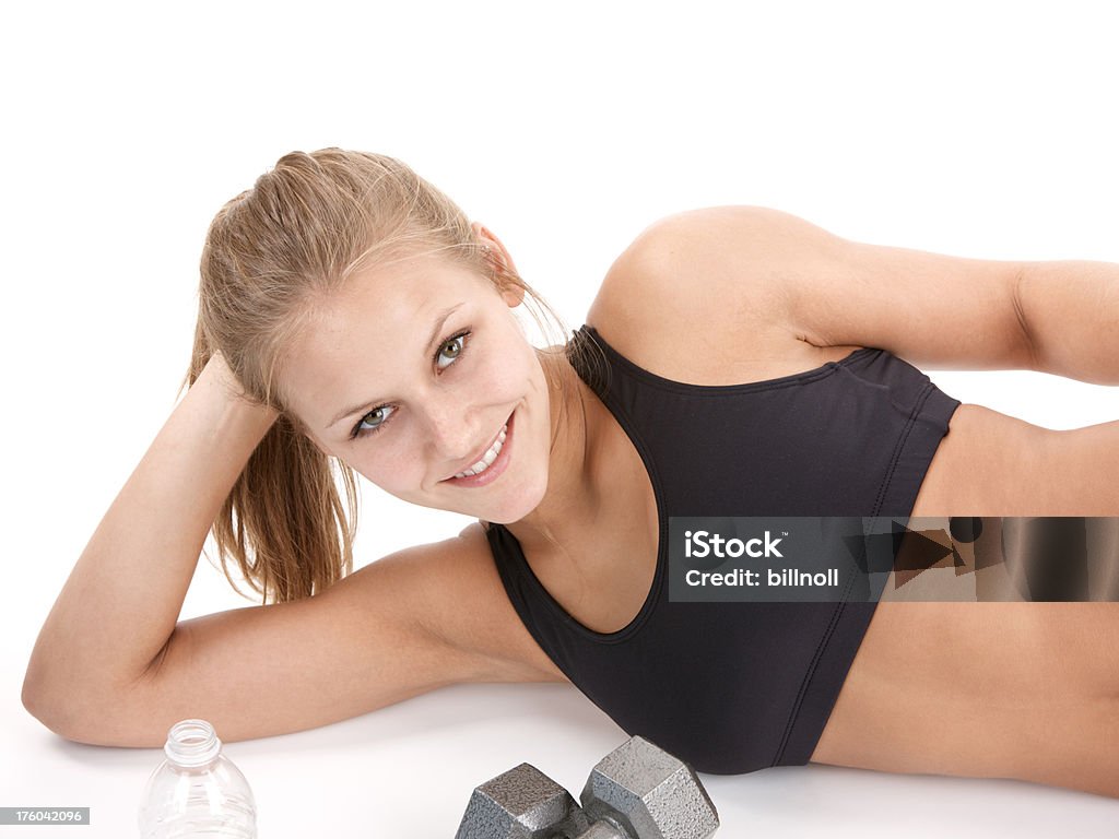 Atletica giovane donna rilassante sul pavimento bianco - Foto stock royalty-free di 20-24 anni