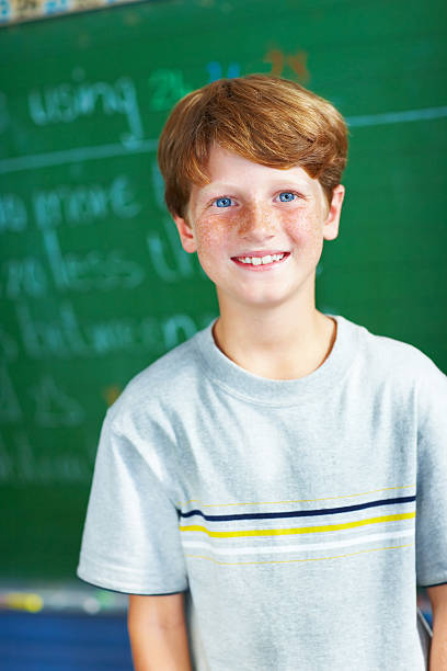 istock Happy schoolboy standing by the board 176042157