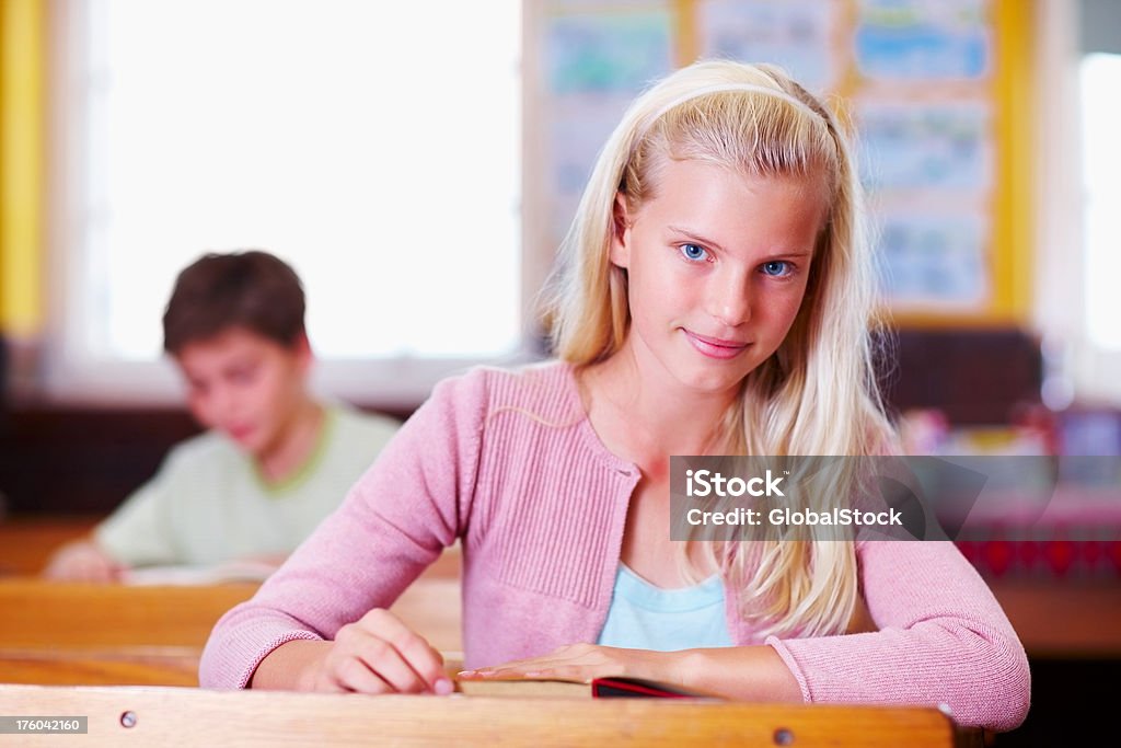 Niña en edad escolar sonriente en montaje tipo aula - Foto de stock de 10-11 años libre de derechos