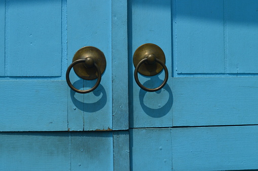 selective focus, pull or door handle in brass and classic design against blue door background.