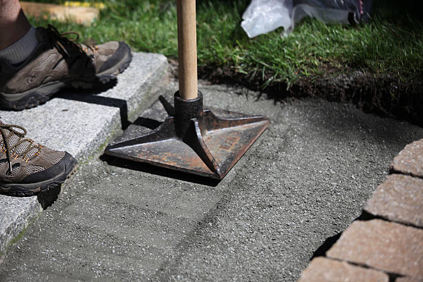 Pounding base of stone paver path stock photo