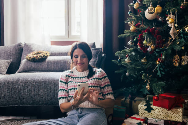 istock A Happy Beautiful Woman Using Her Mobile Phone While Relaxing At Home During Christmas 1760431169
