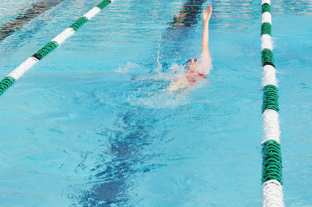 istock Young Girl Backstroke Swimmer Racing in Pool 176043380