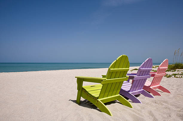 istock Three wooden chairs on beautiful deserted sandy beach 176043833