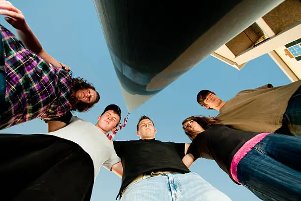 Photo of Teenagers Praying Around a Flag Pole