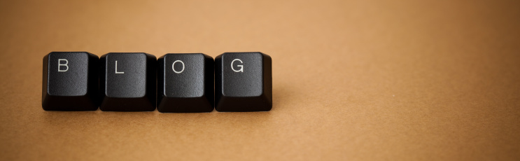 Blog word written on keyboard keys on a brown background. Soft focus. Vignette.