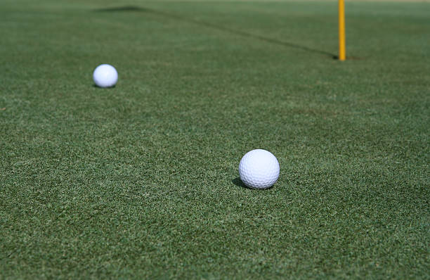 istock Two Golf Balls Near the Pin on a Golfing Green 176045395