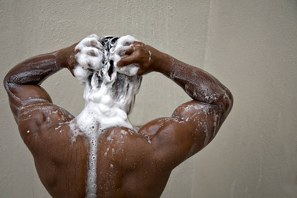 bodybuilder back with soap in the shower "Young man in the shower working up a lather with his shampoo. Flawless dark skin and muscular build, makes for a diverse, squeaky clean image. 50 ASA image for fine detail.  More revealed in my """ shower men falling water soap sud stock pictures, royalty-free photos & images